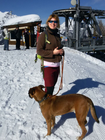 Susanne und Elliot: Start ihrer Winterwanderung an der Bergstation. Susanne mit ihr Hünd Elliot vor einer Bergstation im Winter, bereit für einen Spaziergang auf verschneiten Wegen.