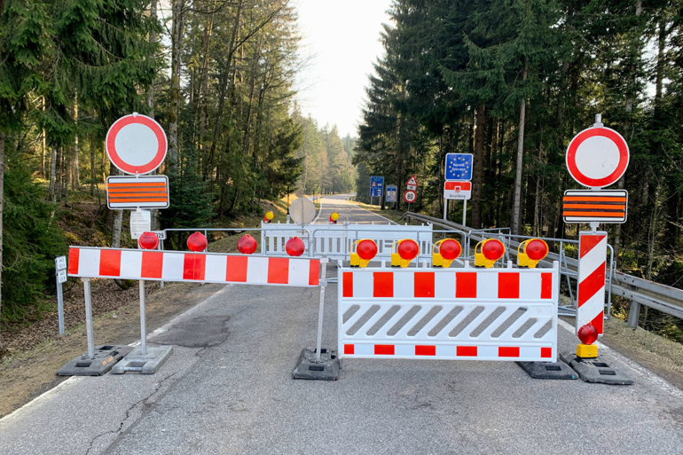 Straßensperre mit Warntafeln an der deutsch-österreichischen Grenze während der Corona-Maßnahmen 2020.