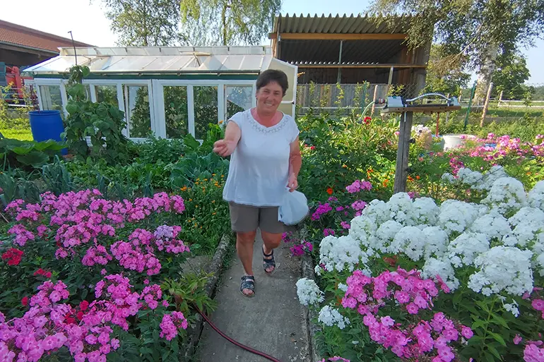 Bäuerin Anni Dorn: Entspannung in ihrem Blumengarten Bäuerin Anni Dorn inmitten bunter Blumen in ihrem Garten.