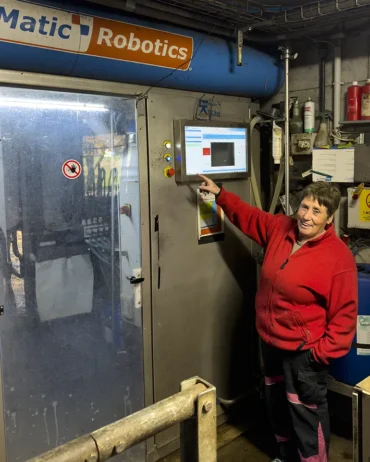 Anni Dorn und der Melkroboter: Effiziente Technik im Einsatz Hier seht ihr Bäuerin Anni vor dem Melkroboter. Der automatisiert den Melkvorgang.
